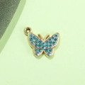 Dettaglio macro di un ciondolo a farfalla con strass azzurri per creazione gioielli DIY - Farfalla Blu Lago Placcata Oro UV