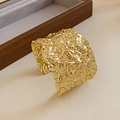 Detailed view of wide gold cuff bracelet with modern hammered texture on beige base - Gold Wrinkled Hammered Texture Style