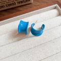 Dettaglio di orecchini a cerchio in resina blu con finitura lucida su vassoio di velluto - Stile C-Shape Largo (59#) / Blu