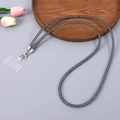 Detail of sparkly diamond mesh crossbody phone lanyard with silver metal clips and tag - Black