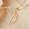 Primo piano del ciondolo a croce placcato oro con zirconi su catena sottile - Croce con Halo Ovale Dorata (24833)