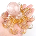 Pink quartz crystal resin octopus figurine with gold leaf accents held in hand - Rose Quartz
