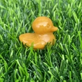 Polished yellow natural stone duck figurine placed on green grass ornament - Yellow Aventurine