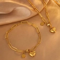 Goldenes Schmuckset mit Herzanhänger und Büroklammer-Halskette auf Seidenhintergrund - Fsy091+fsy754