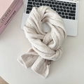 Macro shot of beige cable knit wool scarf texture on a desk with a laptop and books - Beige