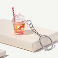 Dettaglio ravvicinato di un portachiavi a forma di tazza di tè ai frutti luminosa - Arancione