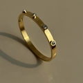 Dettaglio del bracciale rigido placcato oro 18k con ciondoli evil eye e ombre artistiche - Occhio del Diavolo Oro