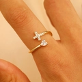 Detail shot of golden double cross ring featuring heart zircon and sparkling pavé stones - Heart Cross Open Style / Gold