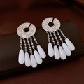 Close-up of sparkling waterdrop tassel earrings with silver finish on dark satin - Round Rhinestone Water Drop Tassel Style / Silver-White Tassel (Silver Pin)