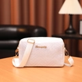 White crossbody camera bag with V-shaped texture and gold hardware on wooden desk - Polka Dot White