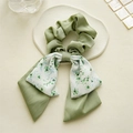 Close-up of green floral bow hair tie on a white ceramic plate with soft lighting - Double Layer Bow / Light Green