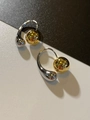 Détail de boucles d'oreilles bicolores en C avec sphère dorée et goutte d'eau argentée - Style Or
