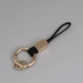 Porte-clés en métal doré avec lanière en cuir noir et fermoir mousqueton - Noir+Or