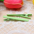 Macro detail of two light green metal duckbill hair clips with non-slip serrated design - Matcha Green