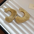 Dettaglio di orecchini a cerchio a C dorati con perline in una scatola per gioielli - Orecchini a forma di C testurizzati oro (perno in argento)