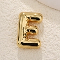 Close-up of gold-plated balloon letter E pendant with metallic texture and wrinkles - Letter E