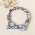 Detailed view of elastic cotton baby headband with blue floral bow on beige background - Ink Cyan Floral