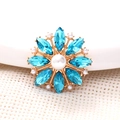 Macro view of blue crystal flower accessory with white pearls and gold metal base - Lake Blue