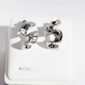 Silver metallic wave drop earrings with a polished mirror finish on a white stand - Stud Earrings / White Gold