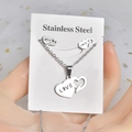 Detail of silver heart necklace and earrings set with LOVE engraving on white card - LOVE Heart