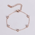 Detalle de pulsera de oro rosa con cinco circonitas redondas engastadas en bisel - Rosa oro