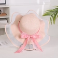Close-up of pink straw sun hat featuring elegant mesh wide brim and silky bow detail - Mesh Edge Pink