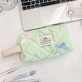 Dettaglio della trousse trapuntata verde chiaro con fiocchi di seta e etichetta in tessuto - Quadretti Verde Frutta
