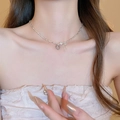 Detail view of silver bow and heart pendant necklace set worn by a model - Heart Bow Pearl Silver Scrap Style Necklace