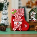 Detail der roten Weihnachtssocke mit Plüsch-Schneemann und gestrickten Akzenten - Schneemann