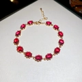 Détail d'un bracelet doré orné de 13 pierres précieuses ovales rouge rubis et fermoir - Or-Rouge