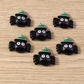 Dettaglio di ragni carini in resina nera con cappelli da strega per decorazioni Halloween - Ragno