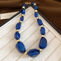 Detailansicht der dunkelblauen Glitzer-Acrylperlen und Gold-Abstandshalter der Halskette - Blau