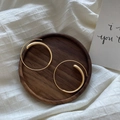 Minimalist matte gold spiral hoop earrings with drop detail on a rustic wooden tray - Alloy / Circular Design / Matte Gold