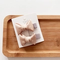 Close-up of pink fabric ribbon bow hair clips on a wooden tray for little girls - 2-Piece Set / Champagne