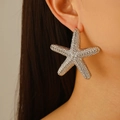 Oversized silver starfish stud earrings with textured finish on a fashion model - Silver Starfish Stud Earrings