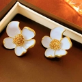 Macro detail of white enamel flower earrings with gold pistils in a vintage style - Silver Earring Post Style / White