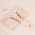 Detail of bohemian polymer clay necklace with pearls and gold heart pendant on marble - Mixed Colorful