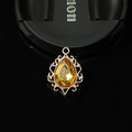 Macro d'une pierre ambre en goutte dans un cadre en filigrane doré pour création de bijoux - Jaune