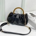 Elegante bolso nube plisado negro con asa de madera y cadena dorada sobre mármol - Negro