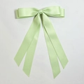 Macro view of mint green double-layered satin bow hair clip with long silk ribbons - Cyan