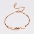 Detalle de pulsera de oro rosa con letras LOVE, cuentas redondas y colgante de corazón - Oro rosa