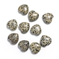 Detailed view of ten heart-shaped dalmatian jasper stone beads on a clean white background - Spotted Stone