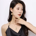 Close-up of golden concentric textured jewelry set with pearls worn by a model - Gold|three-piece Set