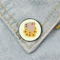 Round cartoon capybara enamel pin with sunflower wreath on blue denim jacket - Sunflower Capybara