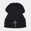 Detailed close-up of a black ribbed knit beanie with white cross embroidery - M (56-58cm) / Black