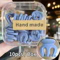 Vista macro de 10 mini pinzas para el cabello azul mate en una caja de regalo cuadrada - 10 Unidades/Caja / Azul claro