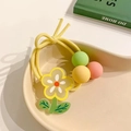 Dettaglio dell'elastico per capelli con fiore giallo e perline colorate in un vassoio - 1 Pezzo / Fiore Giallo