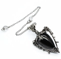 Macro view of black teardrop stone in silver gothic frame with pentagram carvings - Obsidian + Pendulum Chain
