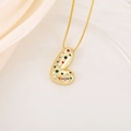 Macro detail of gold-plated abstract letter pendant with multicolored cubic zirconia - L
