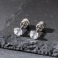 Macro shot of 4mm cubic zirconia stud earrings with screw back on grey stone background - 4mm / Silver
